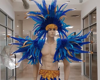 May include: A mannequin wearing a vibrant blue and gold feather costume. The costume includes a headdress, shoulder pieces, a belt, and a skirt, all adorned with feathers. The mannequin is in a well-lit hallway.