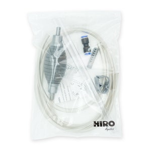 May include: A clear plastic bag containing a gray siphon pump with a clear hose, a gray hose clamp, a gray filter, and a blue connector. The bag has a white label with the text "HIRO Aquatics" printed on it.