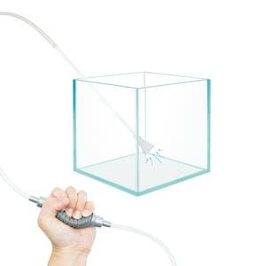 May include: A clear glass aquarium with a gray siphon tube and a white nozzle. The tube is connected to a gray handle and a clear hose. The nozzle is inside the aquarium and water is being sucked out of the aquarium.