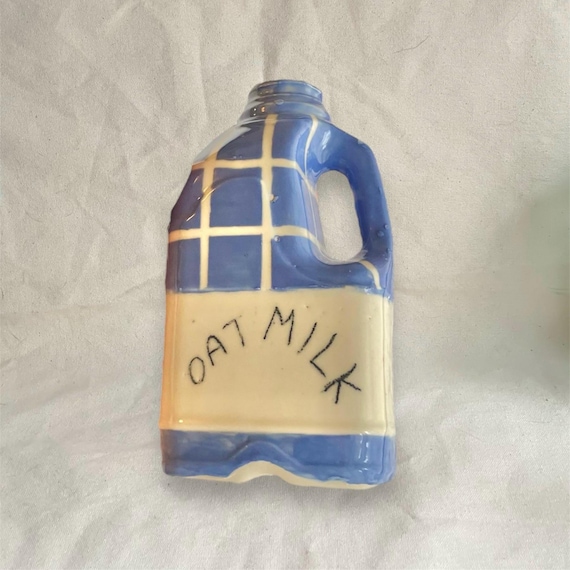 A hand-thrown ceramic vase shaped exactly like an oat milk carton — the kind of deadpan millennial humor that doubles as genuinely beautiful pottery.