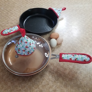 Two sizes of handle covers to fit cast iron or metal handled pans, and the lid grabbers are 4 inches tall.