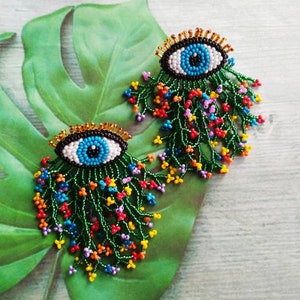 Beaded evil eye earrings with multicoloured flower fringe, Cottagecore earrings studs, Whimsical bead embroidered eye earrings dangle