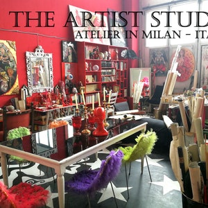 May include: A red room with a black and white tiled floor. The room is decorated with paintings, sculptures, and other art objects. There is a table with four chairs in the center of the room. The text "THE ARTIST STUDY ATELIER IN MILAN - ITALY" is displayed at the top of the image.