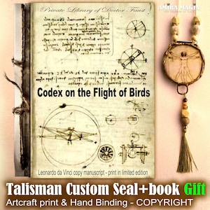 Puede incluir: Un libro abierto con texto manuscrito y diagramas, titulado "Codex sobre el vuelo de los pájaros". Un manuscrito de copia de Da Vinci se muestra junto a un colgante con un diseño del Hombre de Vitruvio, cuentas de madera y una borla. El libro es un regalo personalizado.