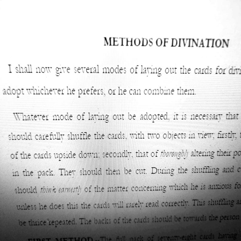 May include: A black and white image of a book page with the title "METHODS OF DIVINATION". The text describes shuffling and laying out cards for divination. The page is from an older book, with a vintage aesthetic.