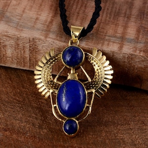 Könnte beinhalten: Goldene Halskette mit einem Anhänger in Form eines Skarabäus mit drei blauen Lapislazuli-Steinen.