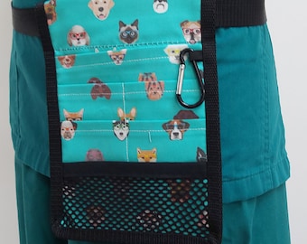 Peut inclure: Un haut de blouse médicale bleu sarcelle avec une ceinture noire et une poche utilitaire à motif bleu sarcelle et blanc avec une poche en filet et un mousqueton.