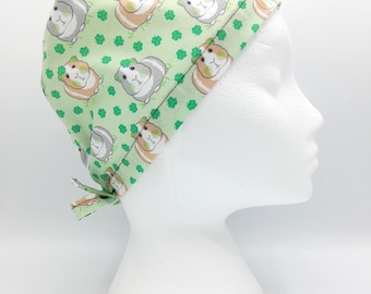 Può includere: Cappello chirurgico verde con un motivo di cavie che indossano cappelli a trifoglio.