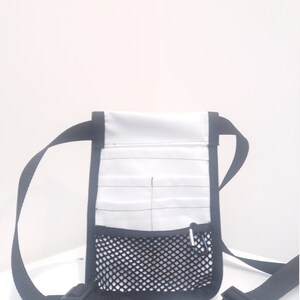 May include: White utility belt bag with a black mesh pocket and black adjustable straps with buckles.