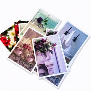 May include: A collection of rectangular photographic prints featuring various scenes including a bouquet of purple flowers on a mantel, a white cloth draped over a rack, pink teacups on a lace tablecloth, and a vibrant arrangement of red and white flowers.