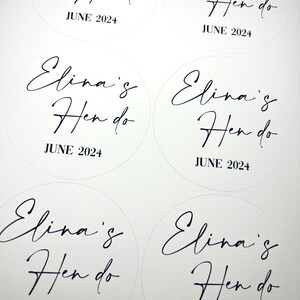 May include: Five white round stickers with black text that reads "Elina's Hen do" and "JUNE 2024".