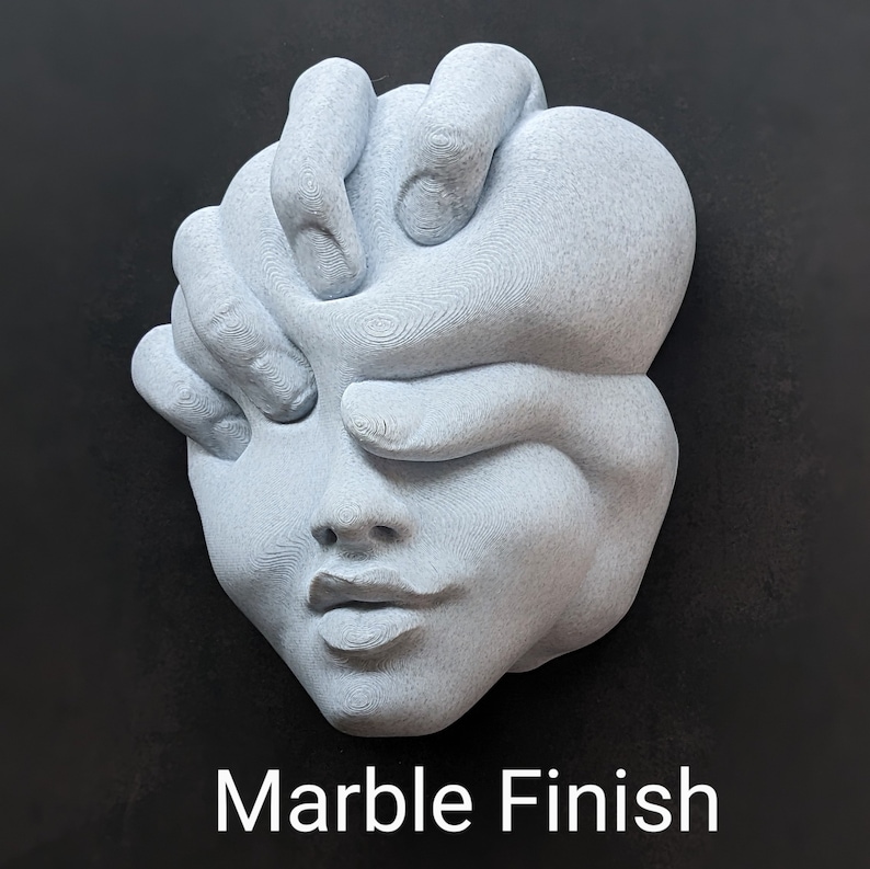 May include: A light gray sculpture of a face with hands covering the eyes. The sculpture has a marble finish and the text "Marble Finish" is displayed at the bottom. The artwork is a unique piece of home decor.