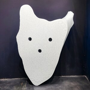 May include: A white, irregularly shaped, three-dimensional object with three circular holes. The object is made of a textured material and appears to be made of foam or a similar material.