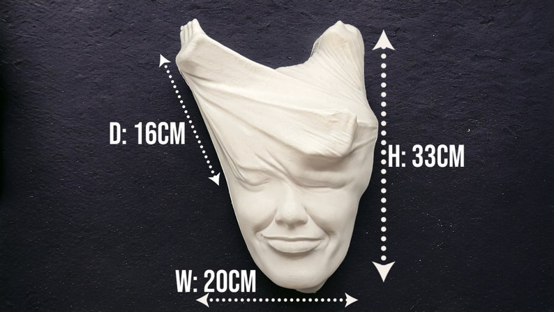 May include: White plaster sculpture of a face with fabric draped over the head. The sculpture is 33 cm tall, 20 cm wide, and 16 cm deep.