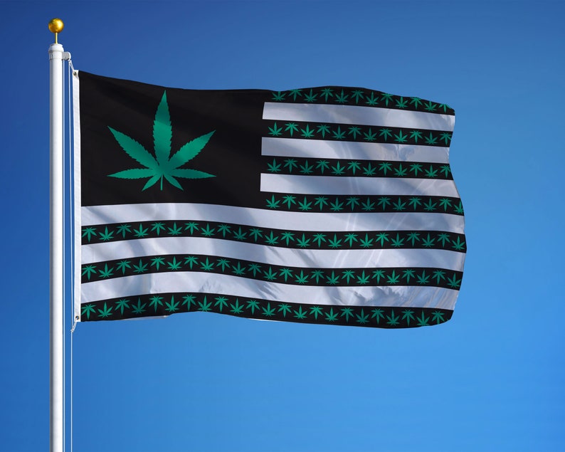 May include: A flag with a black and white striped background. The stripes are decorated with green marijuana leaf designs. A single large green marijuana leaf is in the upper left corner of the flag.