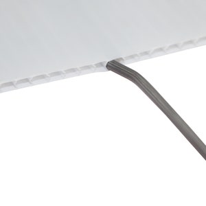 May include: Close-up of a white corrugated plastic sheet with a gray wire coming out of the top edge.