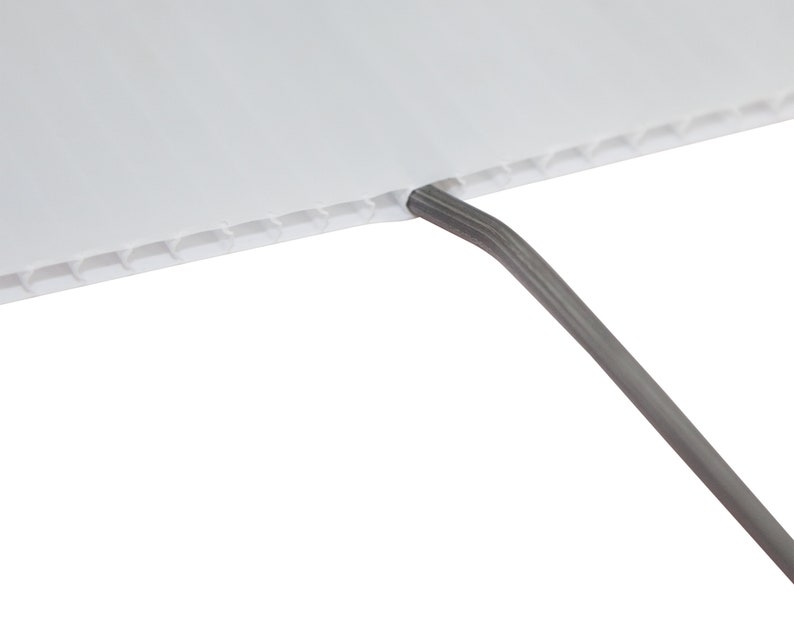 May include: Close-up of a white corrugated plastic sheet with a gray wire coming out of the top edge.