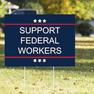 May include: A blue and red yard sign with white text that reads "SUPPORT FEDERAL WORKERS" with three white stars above and below the text.
