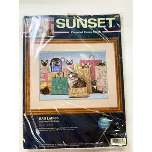 Può includere: Un kit per punto croce contato Sunset intitolato Bag Ladies, che presenta un'illustrazione di diversi gatti che sbucano da varie borse della spesa. La confezione riporta dimensioni di 36 cm per 25 cm e 14 pollici per 10 pollici.