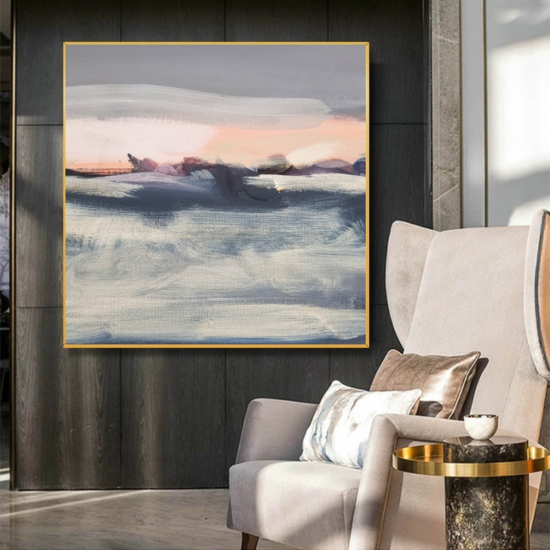 May include: Abstract painting with a gray, blue, and pink color scheme. The painting depicts a landscape with a horizon line and clouds. The painting is framed in a gold frame.