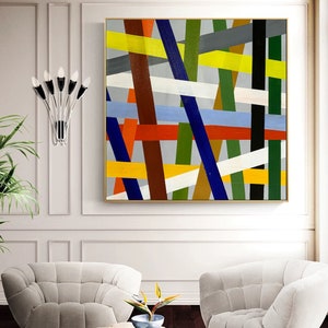 May include: Abstract painting with a geometric design featuring intersecting lines in various colors, including yellow, blue, red, green, white, and brown. The lines are painted on a light gray background.