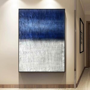 Puede incluir: Pintura abstracta con un esquema de color azul y blanco. La mitad superior de la pintura es de un azul intenso, mientras que la mitad inferior es de un blanco m&aacute;s claro con un acabado texturizado.