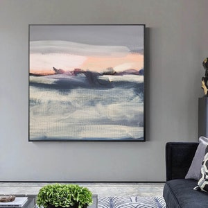May include: Abstract painting with a gray, white, and pink color scheme. The painting depicts a landscape with a horizon line and a sky with clouds. The painting is framed in a black frame.