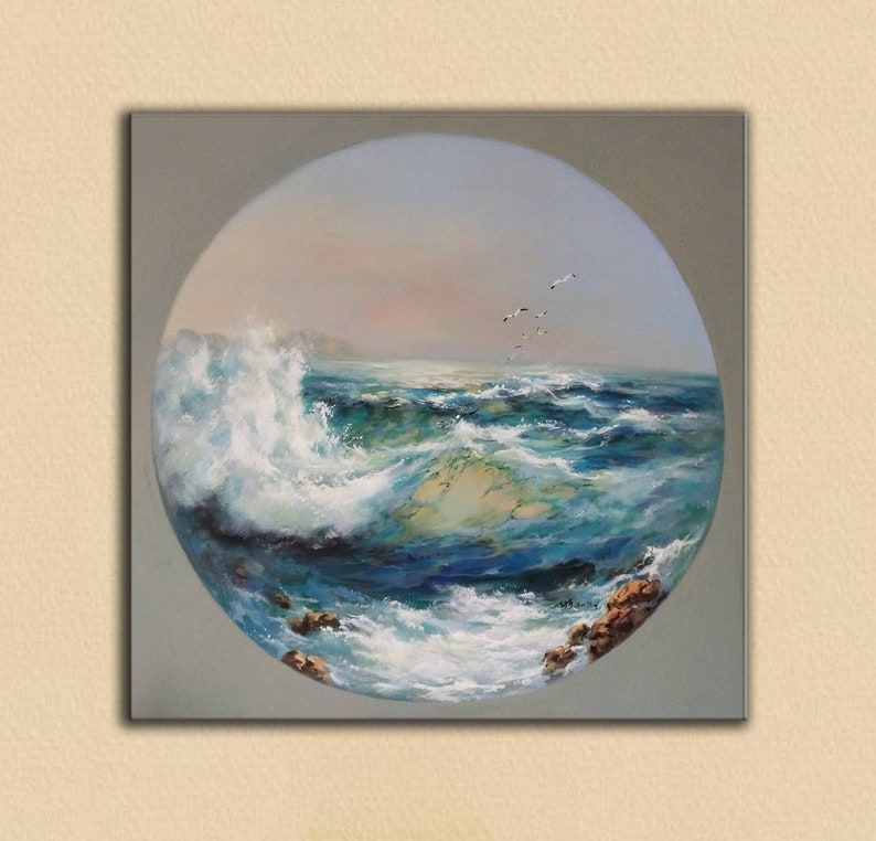 May include: A circular painting depicting a seascape with a large wave crashing against the shore. The water is a vibrant blue with white foam and the sky is a soft blue with a hint of pink. A flock of birds flies overhead.