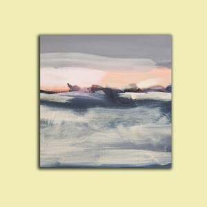 May include: Abstract painting with a soft, muted color palette. The painting features a light pink and gray sky with a dark blue and gray landscape in the foreground. The brushstrokes are visible and create a textured effect.