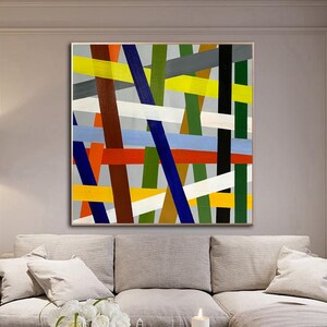 May include: Abstract painting with a geometric design featuring intersecting lines in shades of red, yellow, blue, green, white, and brown on a gray background.