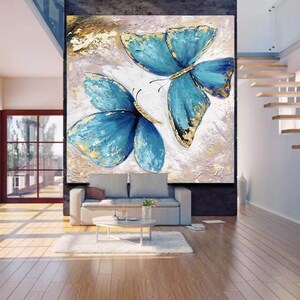 May include: A painting of two blue butterflies with gold accents on a textured white background.
