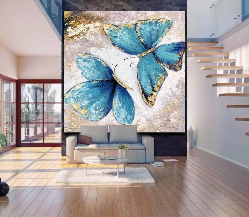 May include: A painting of two blue butterflies with gold accents on a textured white background.