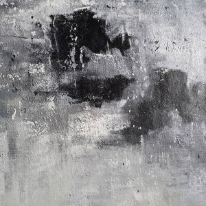 May include: Abstract painting with black and white paint strokes on a canvas. The paint is applied in a thick, textured layer, creating a sense of depth and movement.