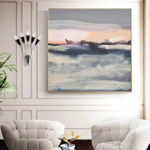 May include: Abstract painting with a gray, white, and pink color scheme. The painting depicts a landscape with a horizon line and clouds. The painting is framed in a gold frame.