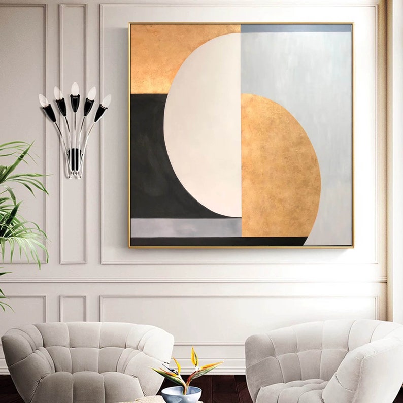 May include: Abstract geometric painting with a gold, black, white, and gray color scheme. The painting features a large circle with a half-circle cut out of it, creating a crescent shape.