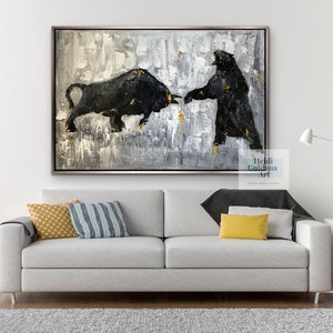 May include: Abstract painting of a black bull and bear facing each other on a gray and white background with gold accents. The painting is framed in a silver frame. The artist's name, Heidi Guldama Art, is in the bottom right corner of the painting.