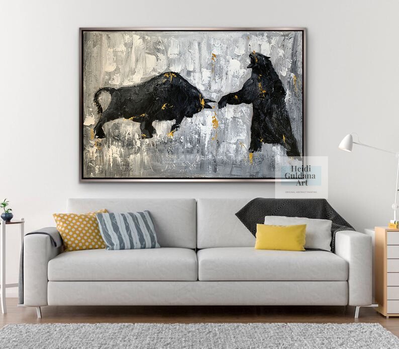 May include: Abstract painting of a black bull and bear facing each other on a gray and white background with gold accents. The painting is framed in a silver frame. The artist's name, Heidi Guldama Art, is in the bottom right corner of the painting.