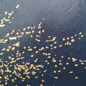 May include: A dark blue background with a scattered pattern of gold dots and dashes.