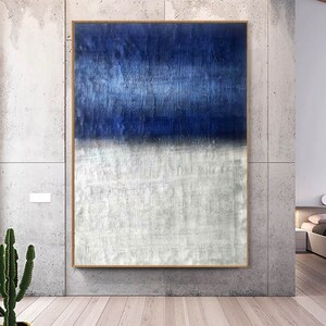Puede incluir: Pintura abstracta con una divisi&oacute;n horizontal de azul y blanco. La mitad superior es de un azul profundo con un efecto texturizado, de pinceladas. La mitad inferior es de un blanco m&aacute;s claro con un efecto texturizado similar.