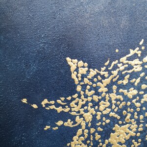 May include: Abstract art painting with a dark blue background and gold accents. The gold accents are in the shape of dots and lines, creating a textured effect.