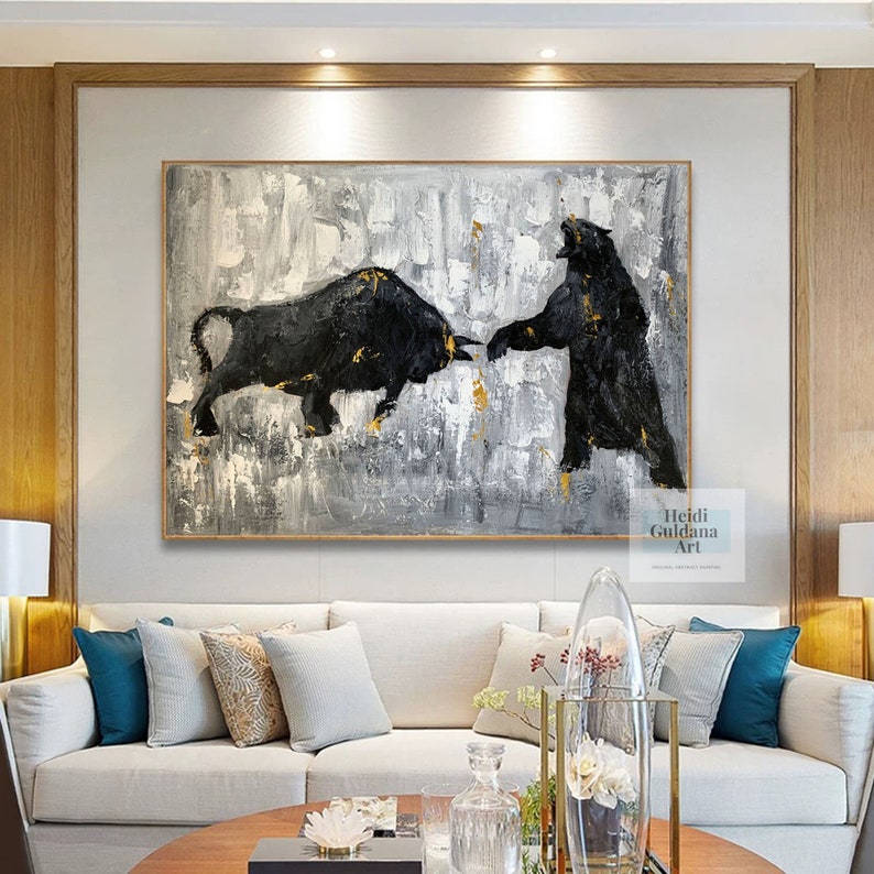 May include: Abstract painting of a black bull and bear facing each other on a gray and white background with gold accents. The painting is signed "Heidi Guildana Art".