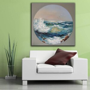 May include: A painting of a seascape with a large wave crashing in the foreground. The painting is in a circular frame and is set against a light green wall.