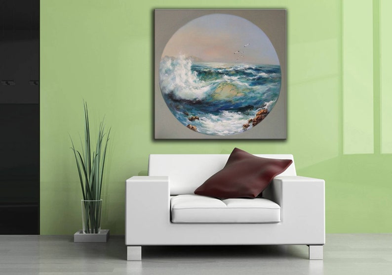 May include: A painting of a seascape with a large wave crashing in the foreground. The painting is in a circular frame and is set against a light green wall.