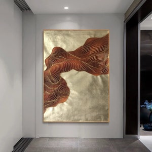 May include: Abstract wall art featuring a flowing, wavy design in shades of brown and gold. The artwork is framed and has a textured, metallic finish.
