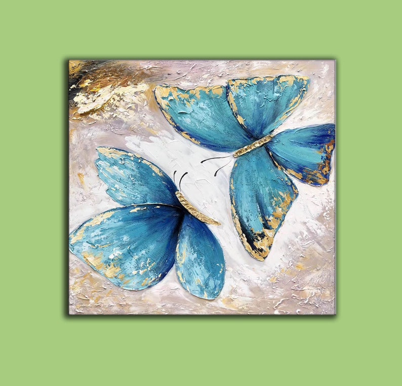 May include: A painting of two blue butterflies with gold accents on a white background.