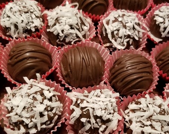 Könnte beinhalten: Nahaufnahme eines Tabletts mit Schokoladentrüffeln, einige sind mit Kokosraspeln bedeckt. Die Trüffel sind in rosa Papier-Cupcake-Förmchen angeordnet.