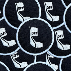 May include: Circular black patches with a white embroidered design and the word "OFF". The patches have a white border. The design is a stylized white shape with the word "OFF" in a white rectangle.