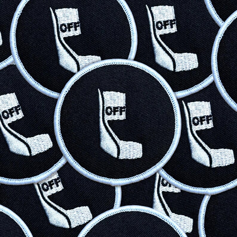 May include: Circular black patches with a white embroidered design and the word "OFF". The patches have a white border. The design is a stylized white shape with the word "OFF" in a white rectangle.