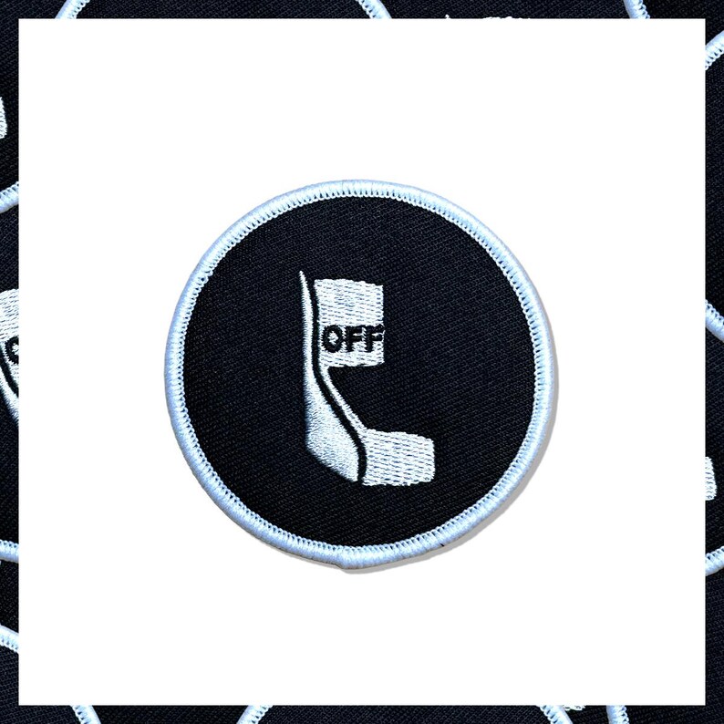 May include: A circular black patch with a white and light blue border. The patch features a white graphic design with the word "OFF" in white text.
