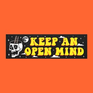 May include: A rectangular sticker with a black background featuring the yellow text KEEP AN OPEN MIND. The design includes a white skull with a ladder inside the cranium, a moon, small white stars, and clouds scattered across the dark surface.